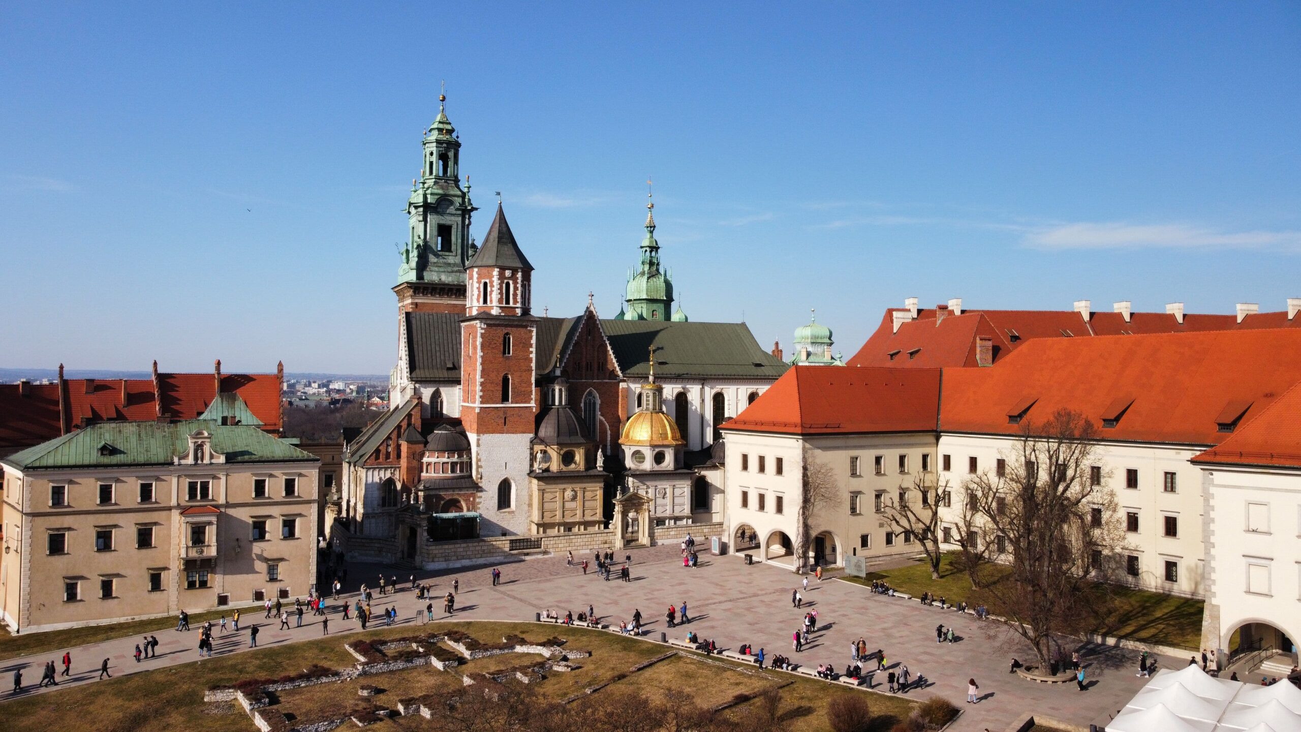 Aerial view of Wawel Cathedral and the castle courtyard under a clear blue sky in Krakow, Poland.