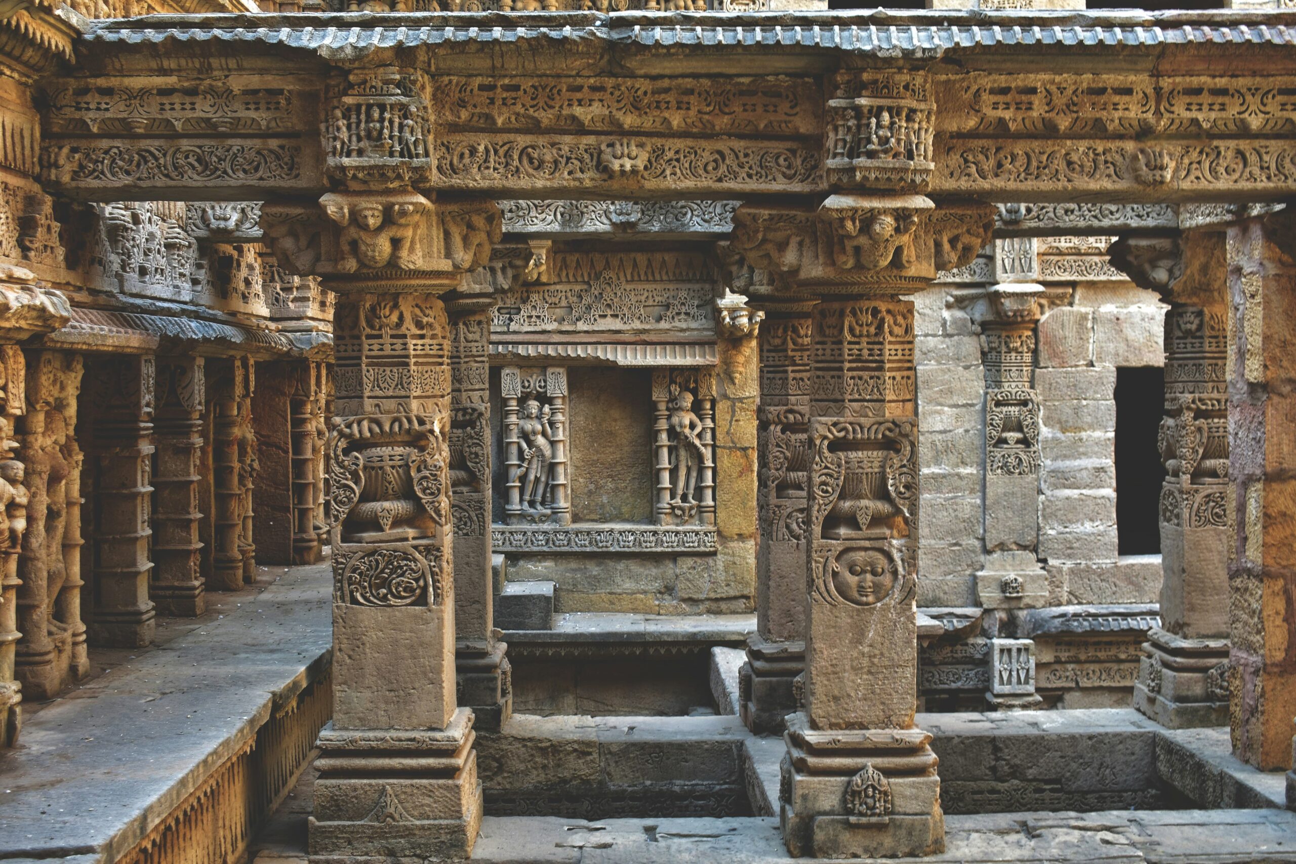 Stone structure with intricate ancient carvings and sculptures on the levels of the Rani ki Vav stepwell.