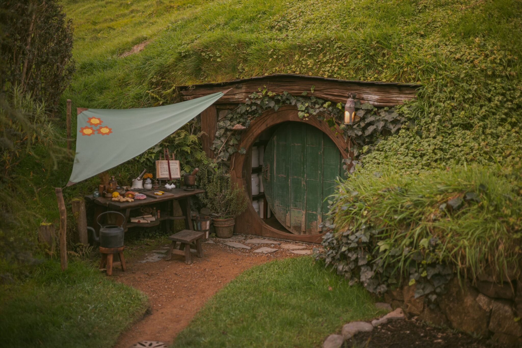 Rustic-style cottage in a lush green rural landscape evoking the Lord of the Rings settings in New Zealand.