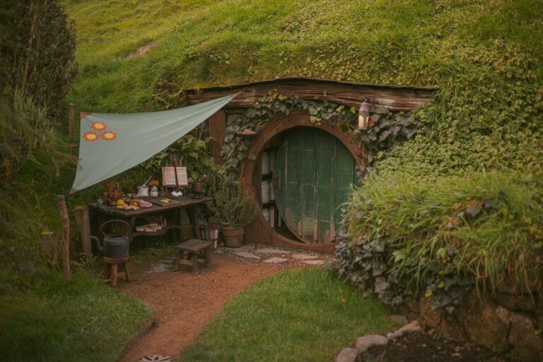 Rustic-style cottage in a lush green rural landscape evoking the Lord of the Rings settings in New Zealand.