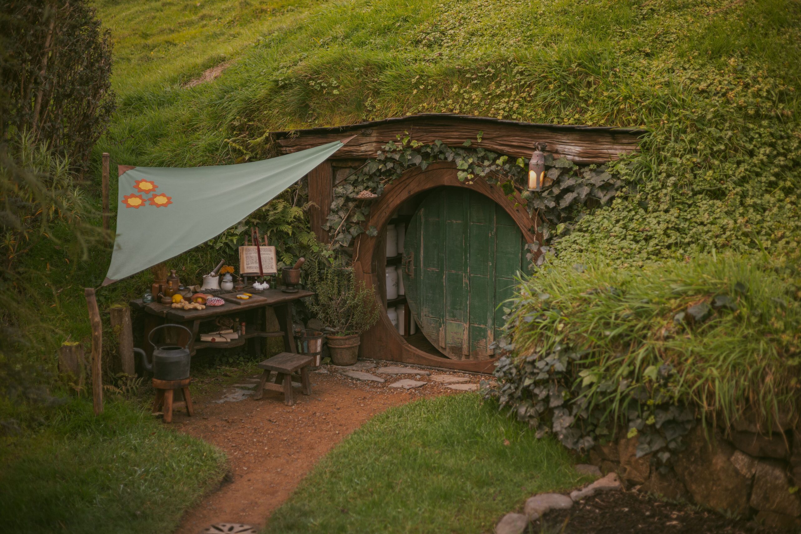 Rustic-style cottage in a lush green rural landscape evoking the Lord of the Rings settings in New Zealand.